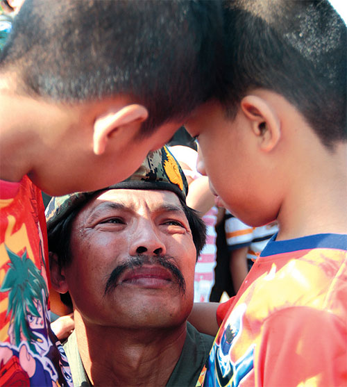 Chief Petty Officer 1st Class Boonsueb Utako is close to tears as he is greeted by his two sons after returning to Thailand yesterday following the anti-piracy mission in the Gulf of Aden off Somalia. PHOTOS BY JETJARAS NA RANONG.