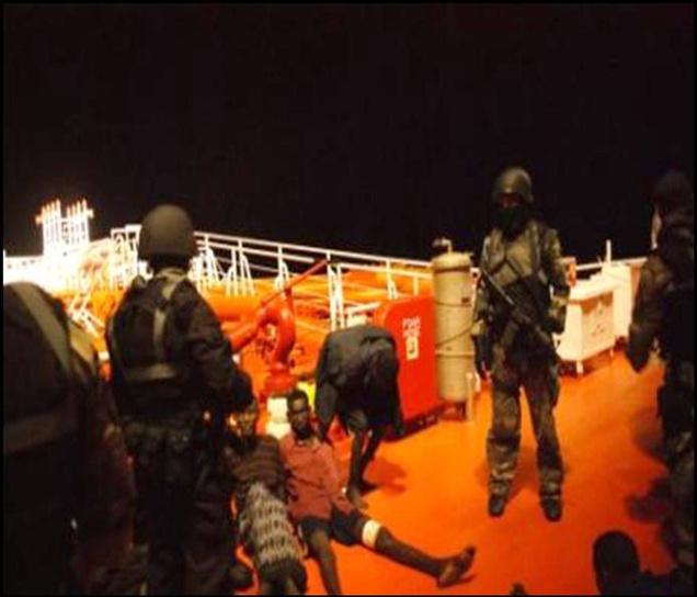 Somalian pirates being guarded by Malaysian naval commandos following a firefight to free a hijacked oil tanker in the Gulf of Aden. Malaysian naval commandos have rescued 23 crew and captured seven Somali pirates. 
