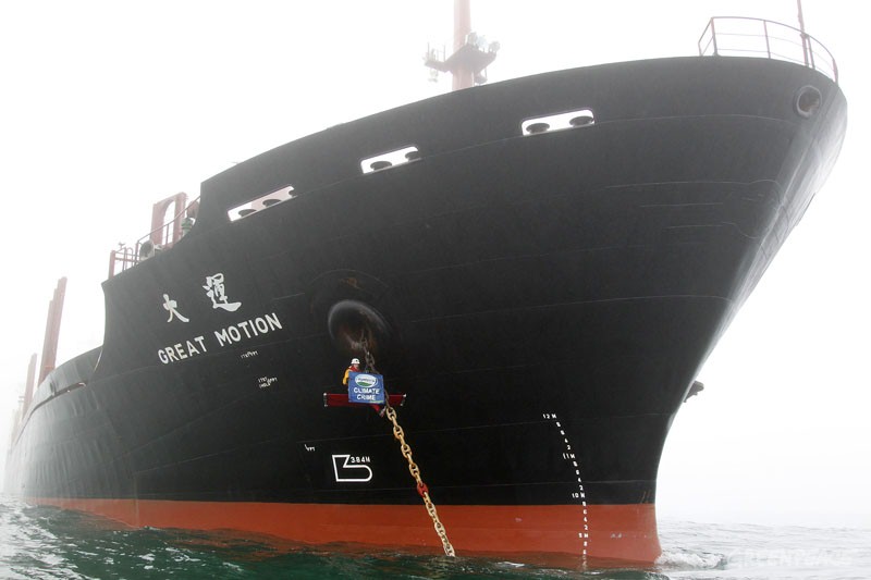 Greenpeace activist Drew Hahn hangs off the anchor chain of the Great Motion. 