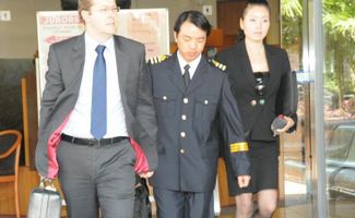 Chief Officer Shen Hui (middle), pleaded guilty at Gladstone Magistrates Court to navigating a ship in a zone where a permit is required.