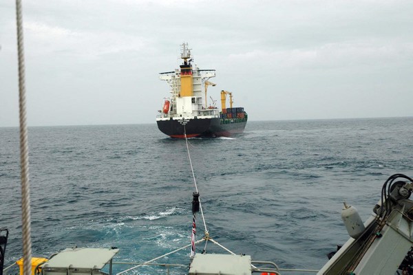  The view of the towing Hawser and MV Vega Fynen's stern from HMAS Broome. Mid Caption: The crew of Royal Australian Navy Patrol Boat HMAS Broome prevented an environmental and maritime disaster off Papua New Guinea overnight by providing assistance to a commercial container ship with no power and adrift. Despite the MV Vega Fynen’s large size and tonnage, HMAS Broome was able to slowly pull the commercial carrier away from immediate danger. The Armidale Class Patrol Boat, dwarfed by the commercial carrier, kept the ship under tow for six hours until passing the tow line to a commercial tug better suited for the role. 