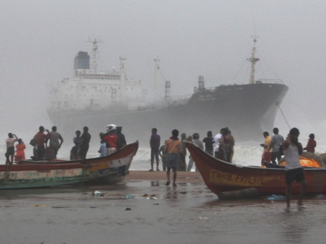Onlookers gather on the beach after the oil tanker ship Pratibha Cauvery ran aground off the coast in Chennai on October 31, 2012. PHOTO: AFP 