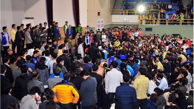 South Korea's president (left, on stage) spoke to relatives of missing passengers, assembled in Jindo port